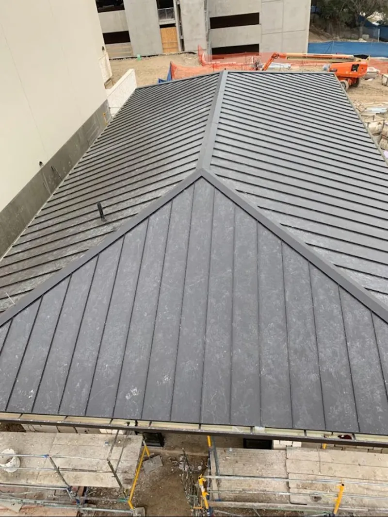 Commercial metal roof construction with crane equipment in Lexington